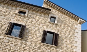 clădire cu aspect mediteranean din cărămidă albă și ferestre elegante cu obloane negre din aluminiu M9300